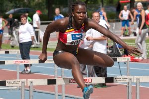 woman jumping over hurdle